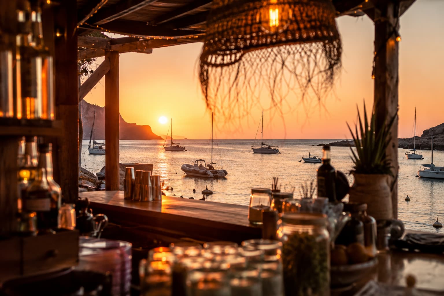 Vista del fondeo de veleros al atardecer desde la barra del restaurante